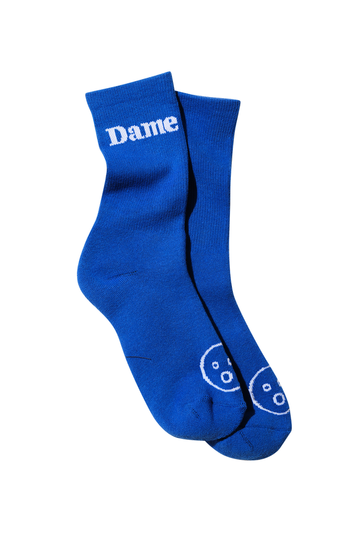 Dame Socks | Two pairs of legs, entangled, all wearing bright blue Dame Socks.