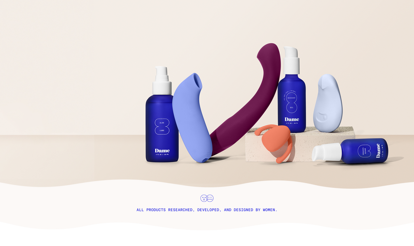 Display of a variety of Dame products (vibrators, massage oils) on a neutral background.