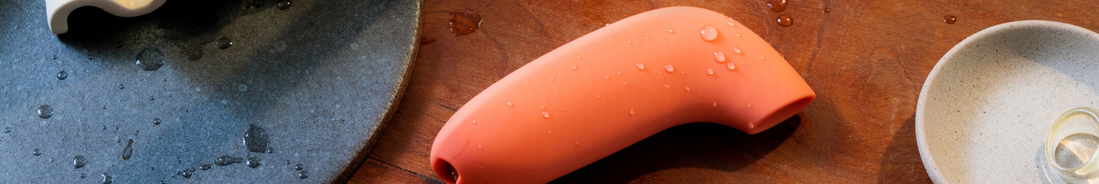 Dame's Aer vibrator in orange on a table