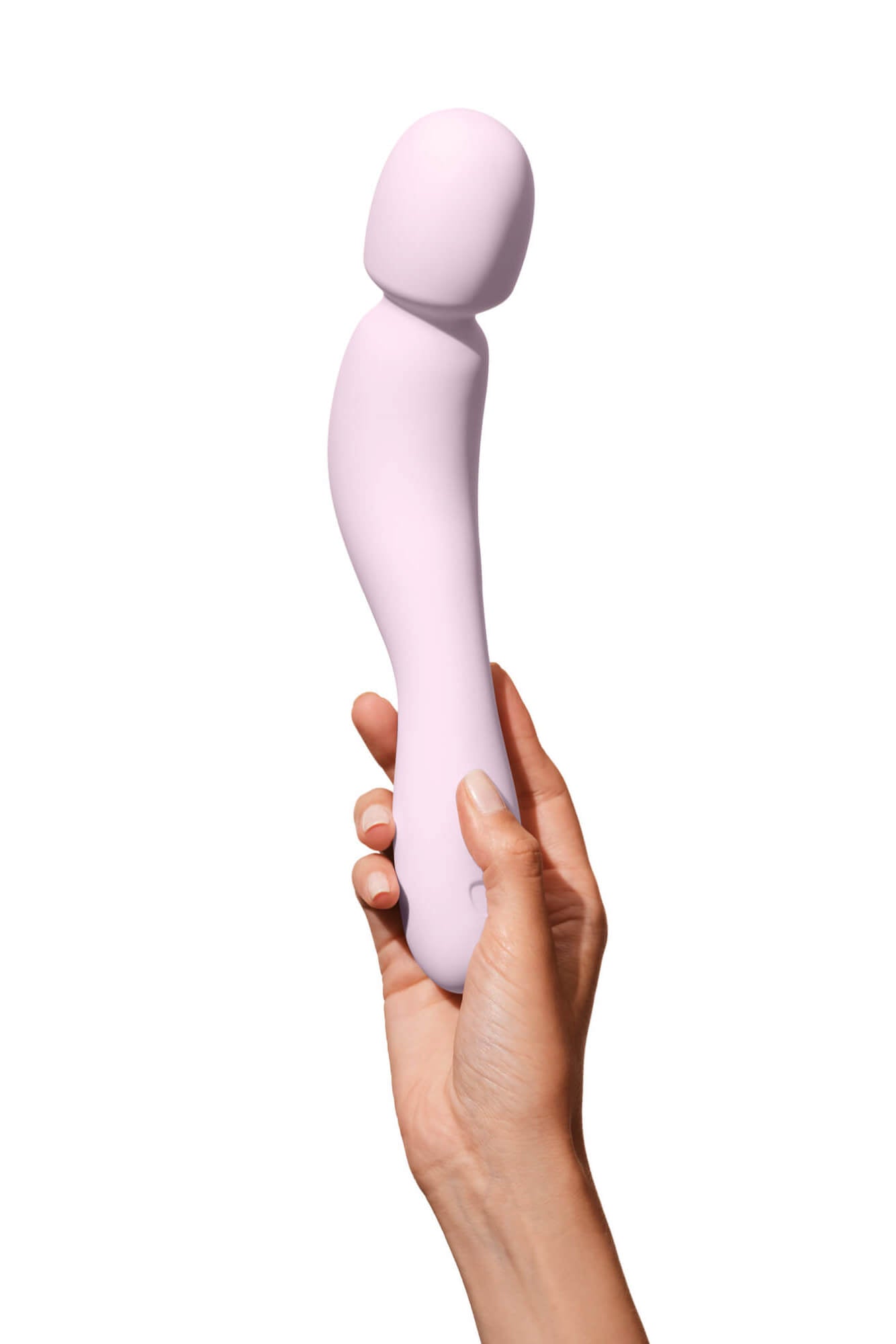 Quartz | Seamless | Quartz pink Com vibrator being held over by a woman's hand.